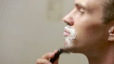 Adam yüzünü tıraş. yakışıklı adam banyoda tıraş.