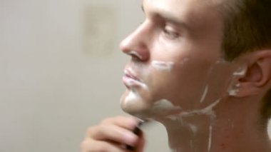 Adam yüzünü tıraş. yakışıklı adam banyoda tıraş.