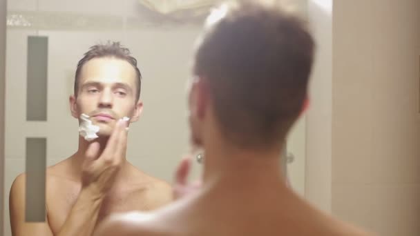 Man scheert zijn gezicht. knappe man scheren in de badkamer. — Stockvideo