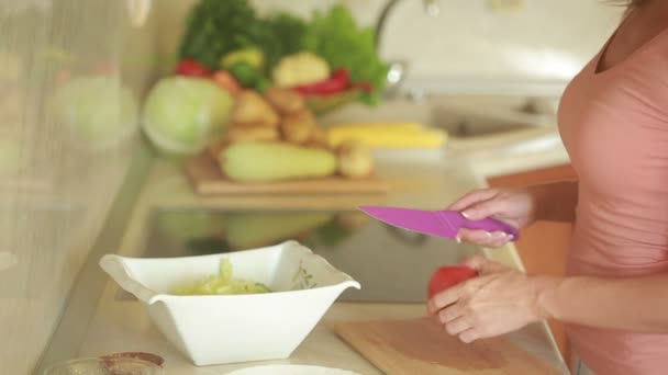 Ung kvinna skära grönsaker i köket för fräsch sallad. tomat — Stockvideo