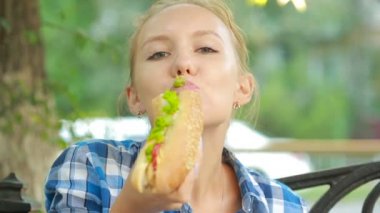 genç kız bir sandviç yeme. Fast food kavramı. sandviç ısırıkları