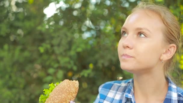 Ung flicka äter en smörgås. snabbmat konceptet. Sandwich bites — Stockvideo