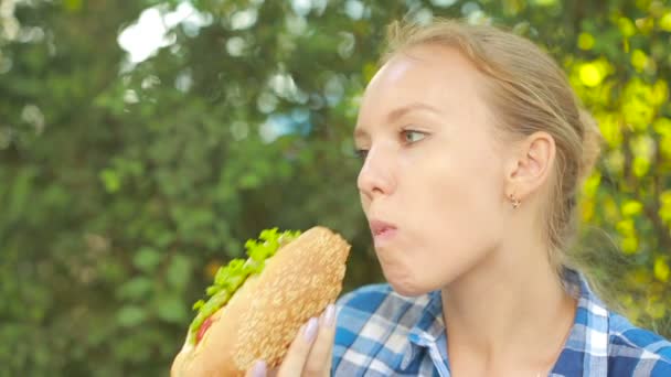 Rapariga a comer uma sandes. conceito de fast food. picadas de sanduíche — Vídeo de Stock