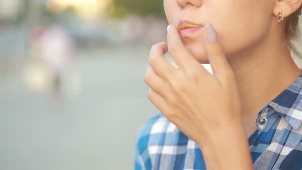 Girl eating chips outdoor in street. Beautiful young woman eating potato crisps. — Stock Video