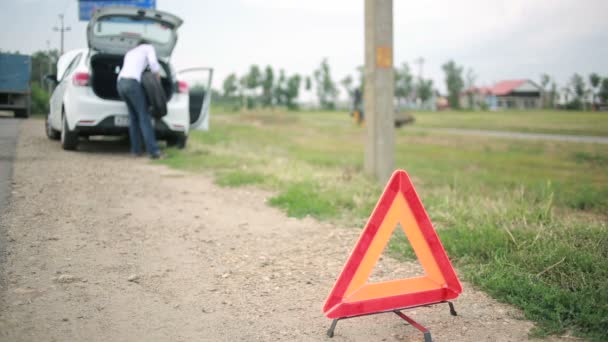 Чоловік змінює колесо машини. прокол на дорозі. зламаний автомобіль — стокове відео