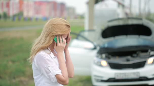 Женщина и сломанная машина просят помощи по мобильному телефону. женщина плачет — стоковое видео