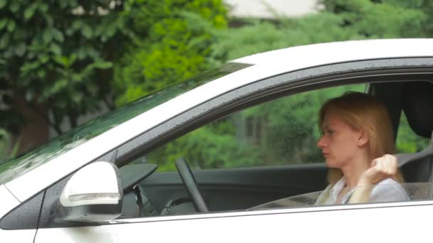 Frau steigt im Regen ins Auto Sicherheitsgurte anlegen — Stockvideo