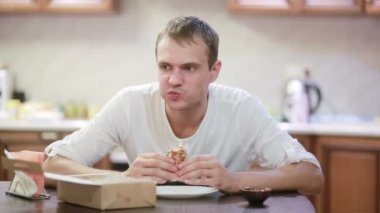 Çiğneme ve patates kızartması evde bir hamburger zevk yakışıklı adam