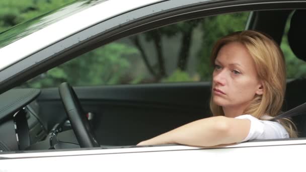 Meisje zit in de auto in de regen. de bestuurder wacht op passagiers — Stockvideo