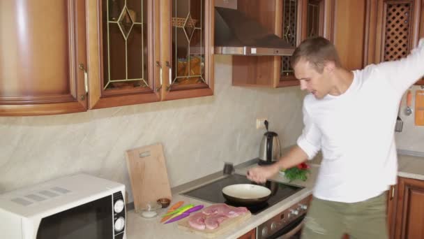 Человек бьет мясо Китченом Мбаппе, веселым парнем, танцующим и готовым еду — стоковое видео