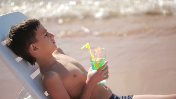 Boy drinking cocktail on tropical beach — Stock Video