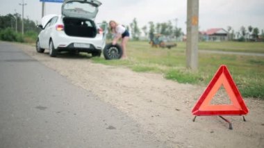 Kız arabada delinmiş bir lastik değiştirme. yolda araba tamiri. kaza