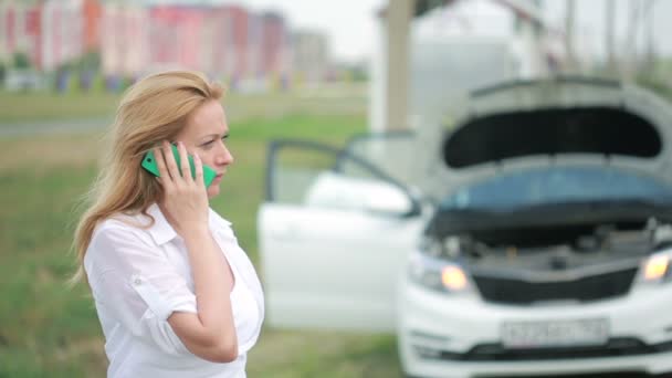 Женщина и сломанная машина просят помощи по мобильному телефону. сломанный автомобиль на дороге — стоковое видео