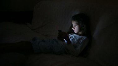 Geceleri bir cep telefonu kullanan küçük kız