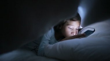 Geceleri bir cep telefonu kullanan küçük kız