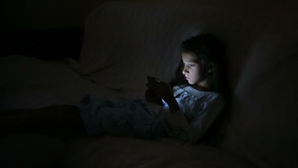 Liten jente som bruker mobiltelefon om natten – stockvideo