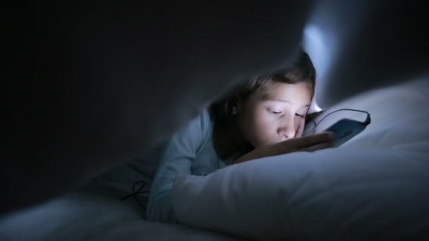 Niña usando un teléfono celular por la noche — Vídeos de Stock