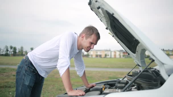 Hombre mirando el motor del coche. hombre reparación de coche roto — Vídeos de Stock