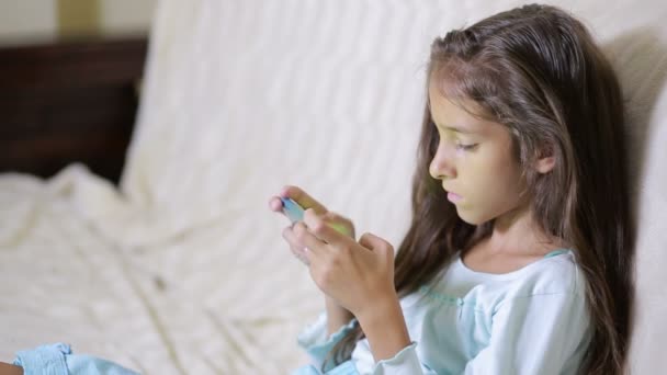 Ragazza bambino con un telefono cellulare naviga in Internet — Video Stock