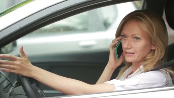 Frustrovaný žena uvízla v dopravní zácpě. dívka mluví po telefonu v autě — Stock video