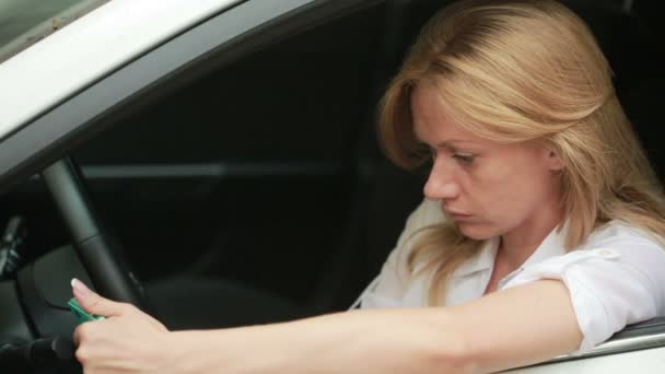 Piękna dziewczyna w samochodzie za pomocą smartfona. dziewczyna siedzi w samochodzie — Wideo stockowe