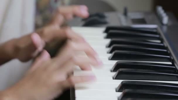 Женщина учит маленькую девочку играть на пианино. музыкальные инструменты — стоковое видео