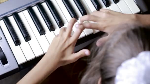 Рука на клавіші піаніно в крупним планом. дитина вчиться грати на піаніно — стокове відео