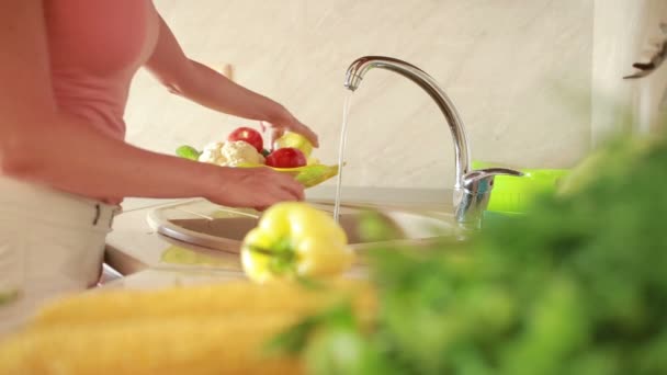 Mädchen wäscht Trauben. Gemüse auf dem Küchentisch. Tomaten und Kohl — Stockvideo