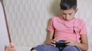 smartphone ve müzik veya evde oyun oynarken kulaklıklar çocuk