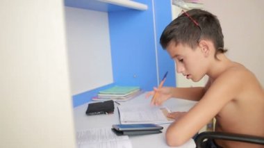 Genç çocuk bir cep telefonu kullanarak ödev yapmak. doğal video