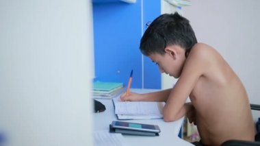 Genç çocuk bir cep telefonu kullanarak ödev yapmak. doğal video