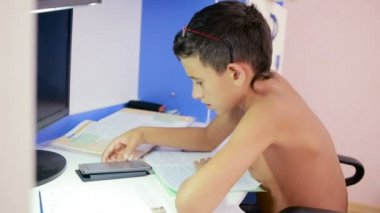 Genç çocuk bir cep telefonu kullanarak ödev yapmak. doğal video