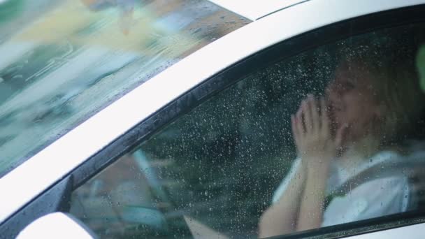 Sad girl crying in the car. rain on the street. woman in hysterics — Stock Video