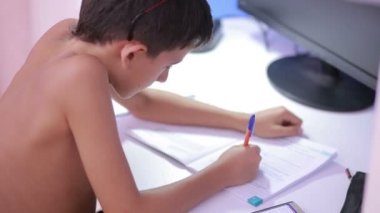 Genç çocuk bir cep telefonu kullanarak ödev yapmak. doğal video