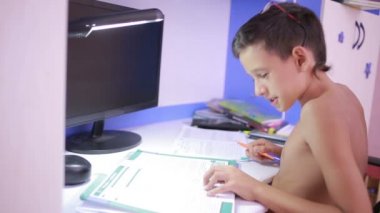 Genç çocuk bir cep telefonu kullanarak ödev yapmak. doğal video