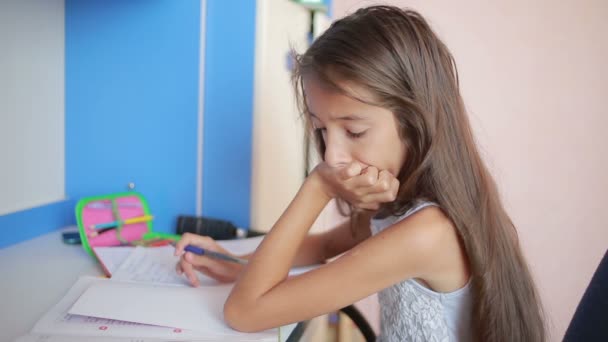 Μαθήτρια που κάνει την εργασία στο τραπέζι φύλλα μέσα από το βιβλίο. Κορίτσι κάνει μαθήματα — Αρχείο Βίντεο
