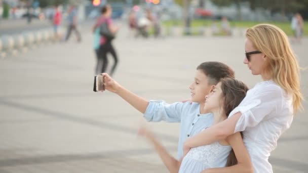 Mom with son and daughter are doing selfie. family photo on the phone — Stock Video