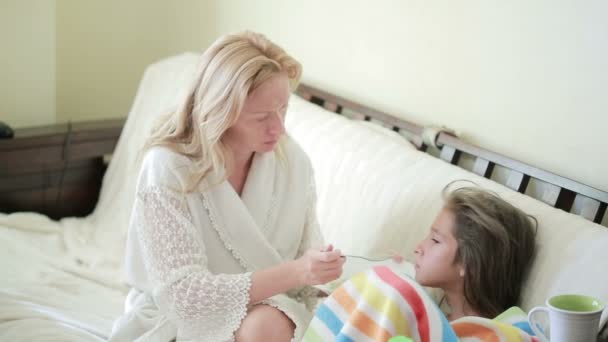 Madre trata a un niño enfermo. Mamá ayudando a una niña a recuperarse . — Vídeos de Stock