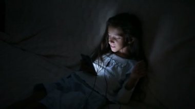 Geceleri bir cep telefonu kullanan küçük kız