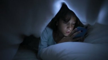 Geceleri bir cep telefonu kullanan küçük kız