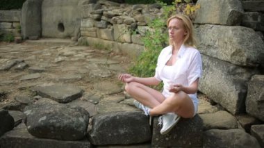 oturma ve taş dolmen üzerinde meditasyon kadın