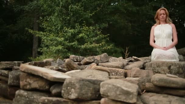 Vrouw zitten en mediteren op stenen hunebed — Stockvideo