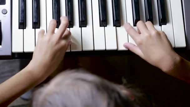 De hand op piano sleutel in close-up shot. kind leren om de piano te spelen — Stockvideo