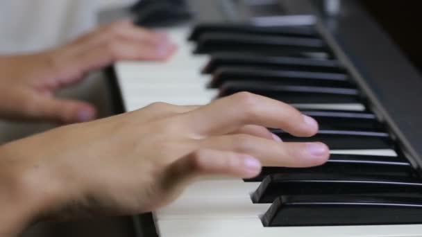 De hand op piano sleutel in close-up shot. kind leren om de piano te spelen — Stockvideo