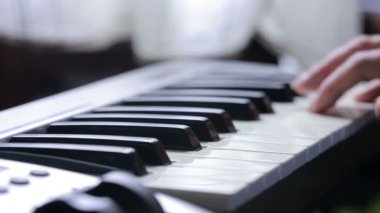 Denetleyici bir MIDI klavye synthesizer oynarken kadın el yakın çekim.