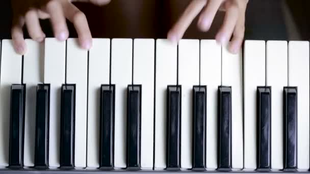 De hand op piano sleutel in close-up shot. kind leren om de piano te spelen — Stockvideo