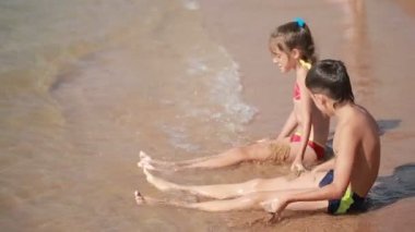 çocuklar. erkek ve kız sahilde kum ile oynuyor. Kumdan kale inşa