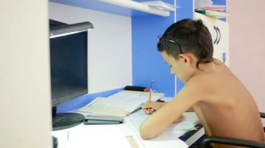 Genç çocuk bir cep telefonu kullanarak ödev yapmak. doğal video