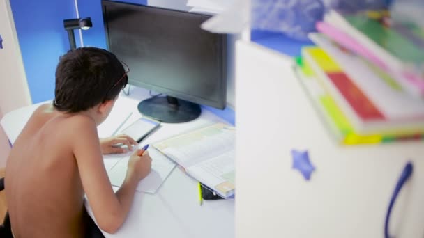 Adolescent faisant ses devoirs avec un téléphone portable. vidéo naturelle — Video