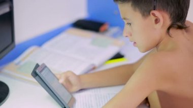 Genç çocuk bir cep telefonu kullanarak ödev yapmak. doğal video